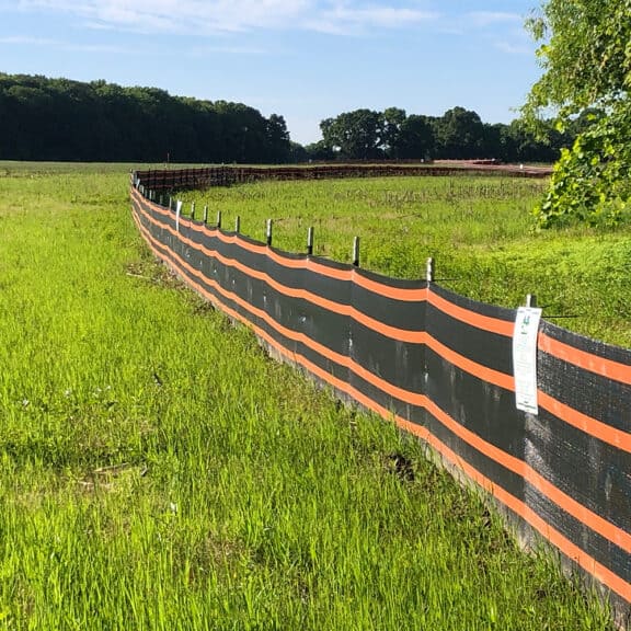 A heavy duty silt fence erected across a large pasture