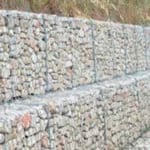 Stacked cage gabions filled with rock for construction foundation