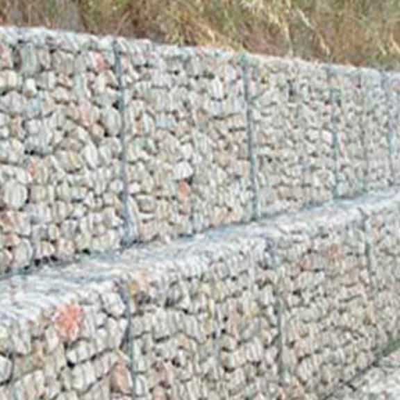 Stacked cage gabions filled with rock for construction foundation