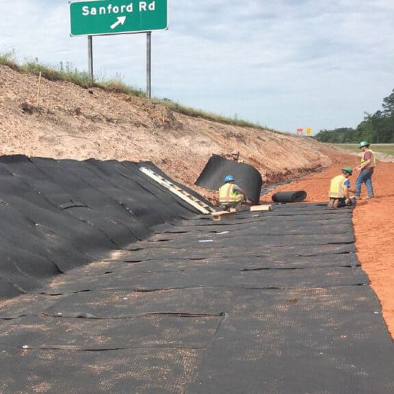 Wall drains being installed along an exit ramp to reduce pooling