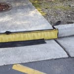 A temporary, low-profile curb inlet filter that handles high flows