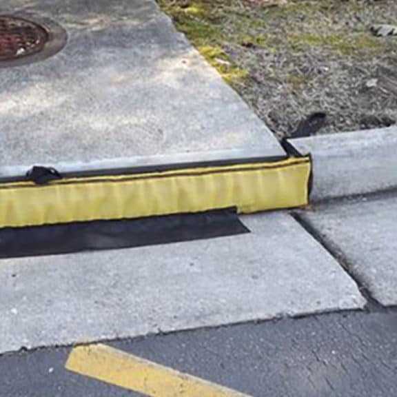 A temporary, low-profile curb inlet filter that handles high flows