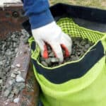 A professional on a construction site filling the RockIn Filter with stone