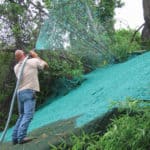 Professional spraying hydraulic mulch on a slope to prevent erosion and encourage vegetation