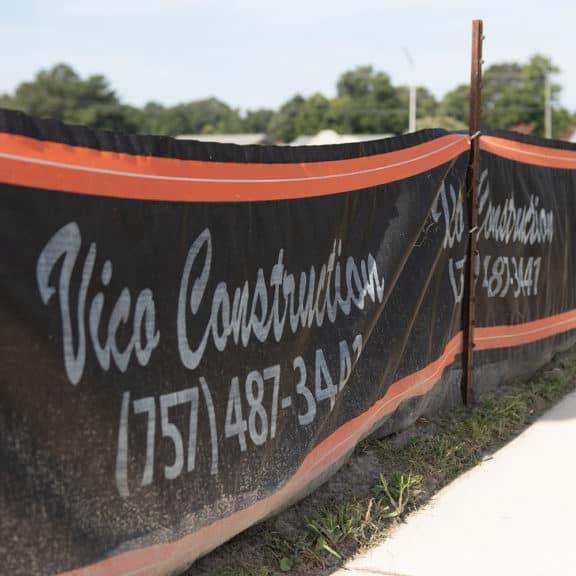 A custom branded silt fence printed with construction companies logo & phone number