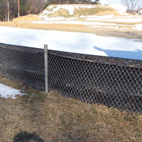 A DOT-approved super silt fence installed on the perimeter of a construction site near a roadyway