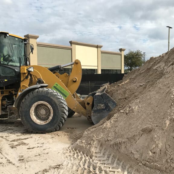 Bold & Gold Filtration Media being poured from a large funnel onto a job site for stormwater management