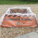 A portable concrete washout berm sitting on gravel at a construction site