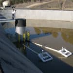 Two skimmers floating in a basin, slowly draining draining it and extracting pollutant-free water