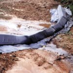 A temporary check dam known as a triangular silt dike on a muddy job site