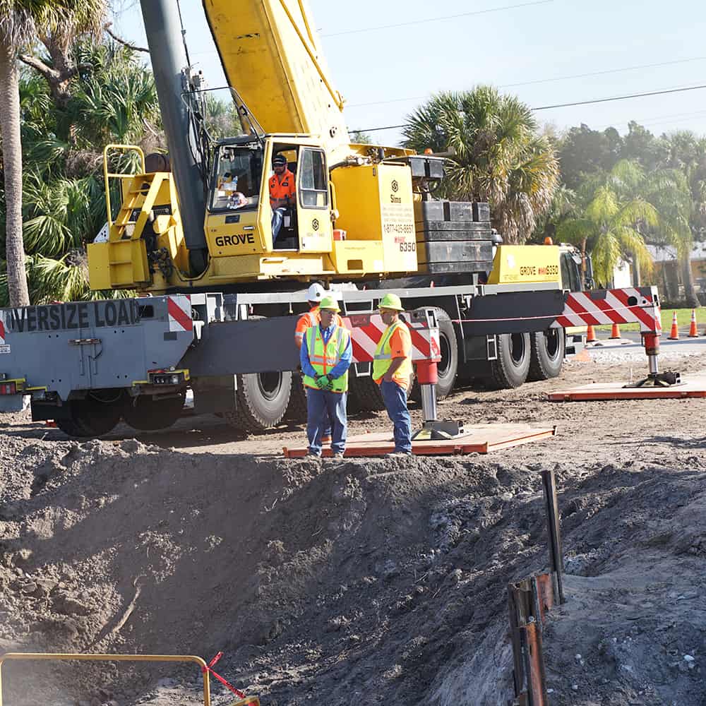 A roadside construction site with workers discussing the project with Ferguson Waterworks