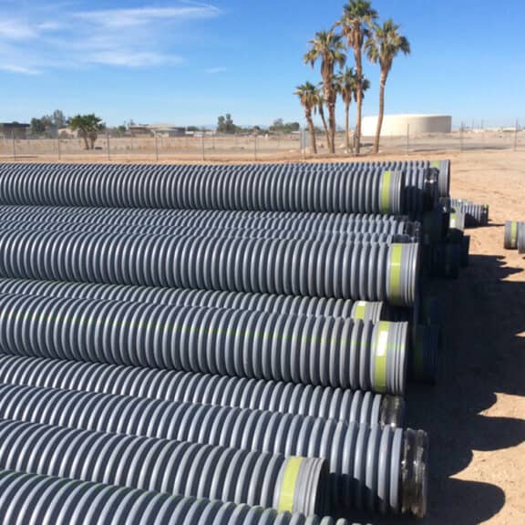 A large stack of HP Storm Pipe on a construction site