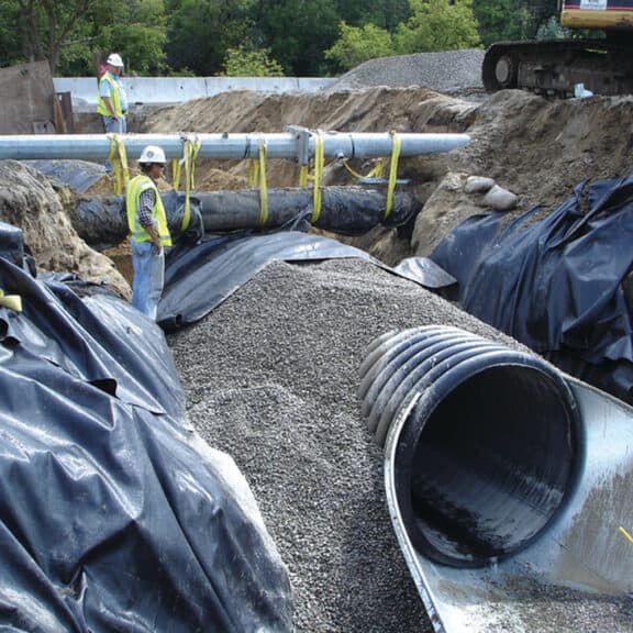 N-12 Dual Wall Pipe on a construction site being set beneath the ground